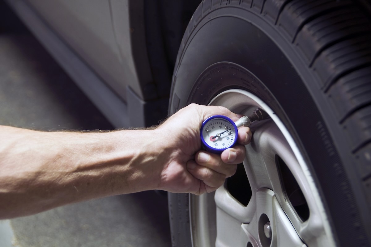 Checking tire pressure before an Arizona road trip